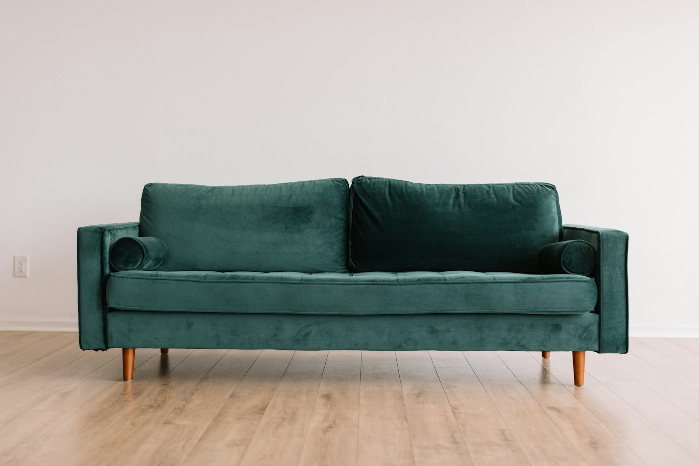 Deep green sofa against a pale wall
