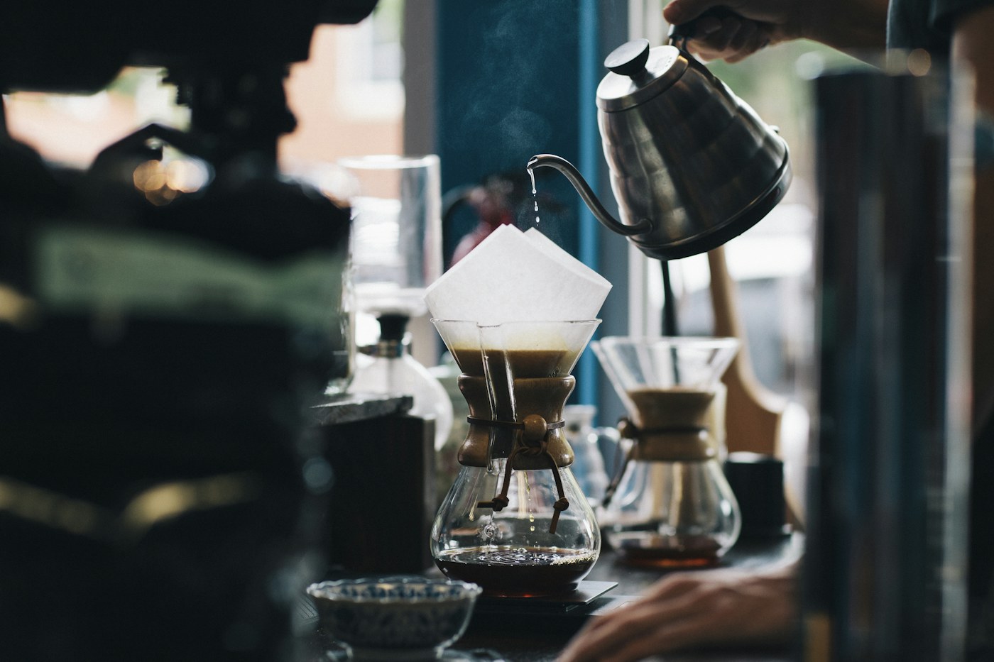 Pour-over coffee being prepared beside a window