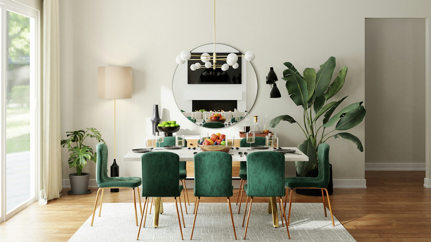 Dining table with green chairs, a round mirror and houseplants