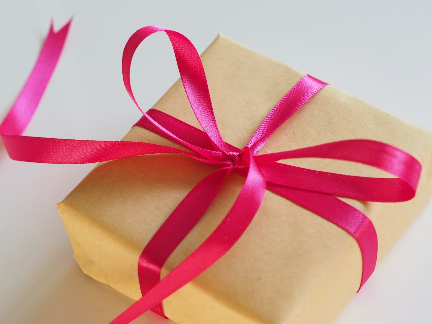 A present wrapped in brown paper and a pink ribbon